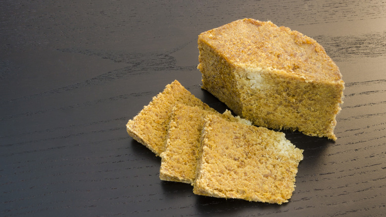Slices of gamalost cheese on a wooden surface.
