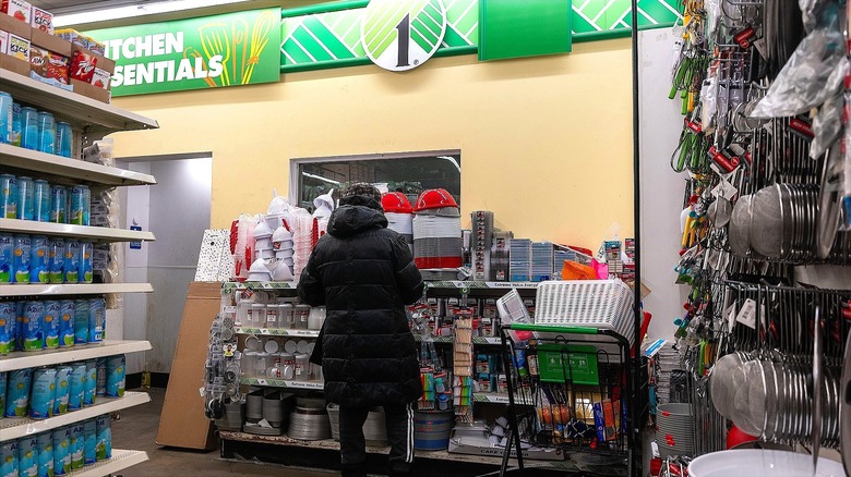 Dollar Tree shopper in a puffy black coat looking at kitchenware