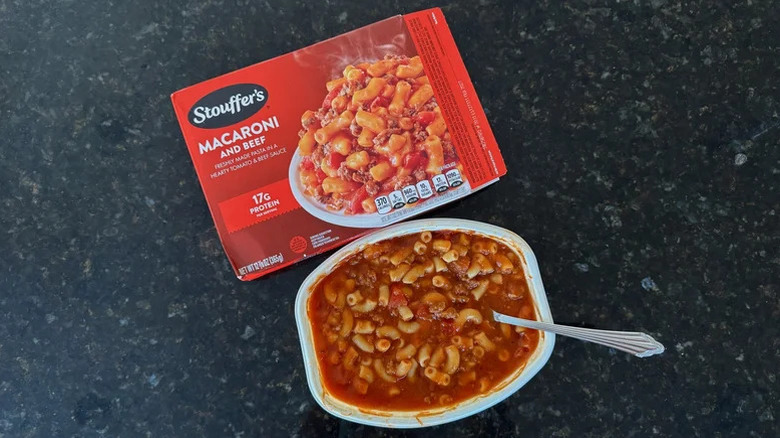 Stouffer's macaroni and beef box next to a heated macaroni and beef meal