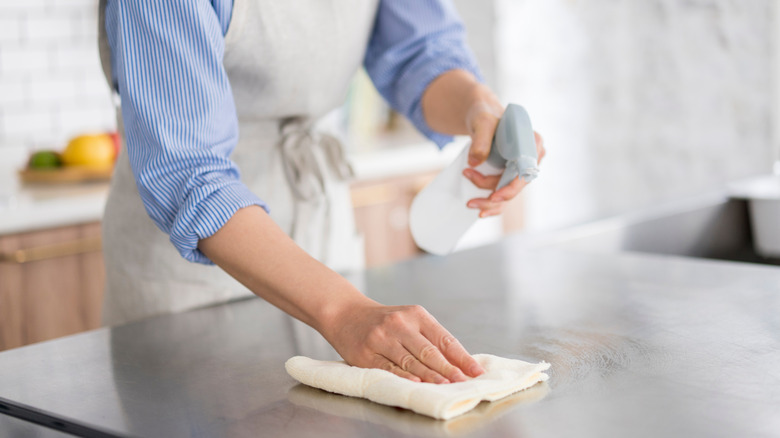Person cleaning a kitchen counter