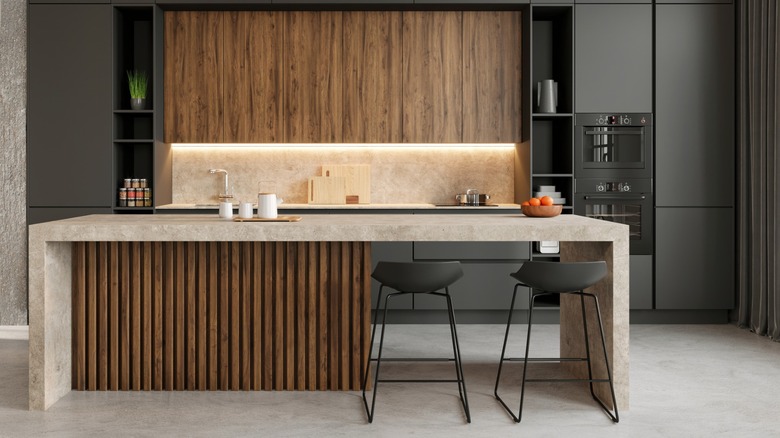 Single-wall kitchen layout with hybrid kitchen island, integrated appliances, and natural light