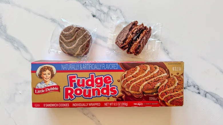 Fudge Rounds cookies and box on white marble countertop.