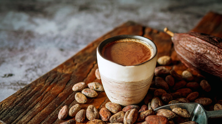 a cup of drinking chocolate and cacao beans