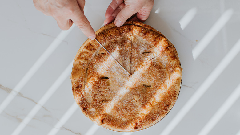 Person cutting a pie