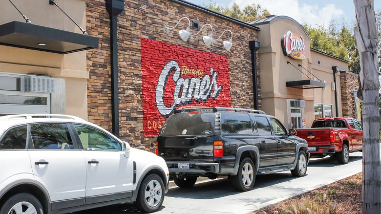Customers wait in line at a Raising Cane's restaurant