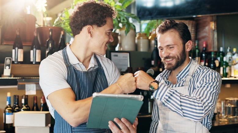 Wait staff fist-bumping over a menu