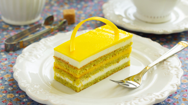 Rectangular piece of lemon cake with a fork on a small white plate