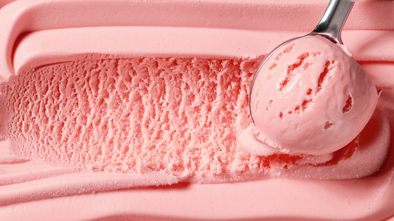 closeup of ice cream spoon scooping pink ice cream