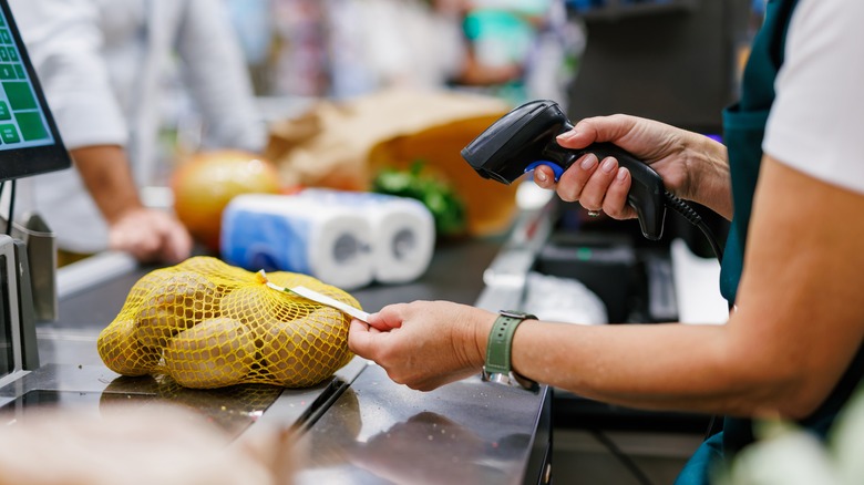 Cashier scanning a bag of potatoes