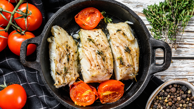 Cod cooking in a cast iron pan