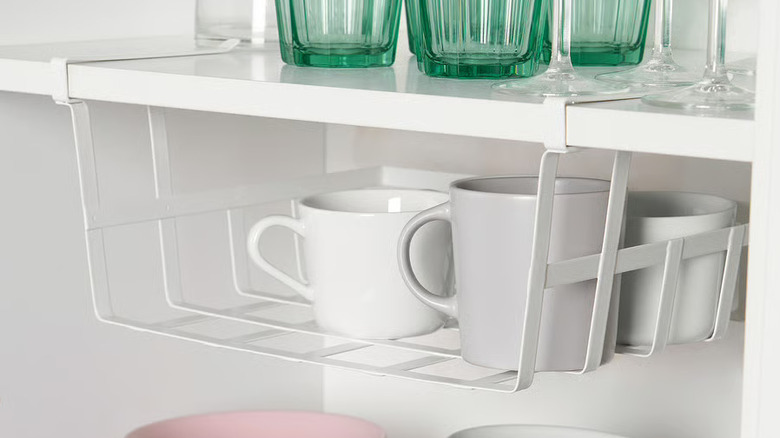 Ikea's Pålycke Clip-On Basket filled with ceramic mugs.