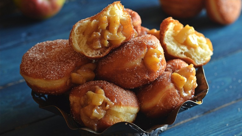 Ornate bowl filled with cinnamon sugar donuts stuffed with apple pie filling