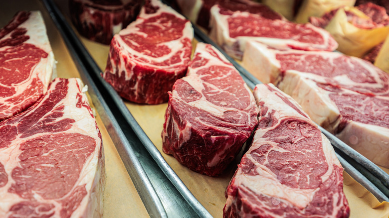Steaks are displayed at a butcher counter