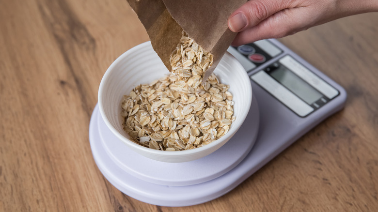 Hand measuring rolled oats on a food scale