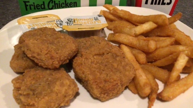 A plate of Beyond Fried Chicken nuggets, fries, and hot honey mustard