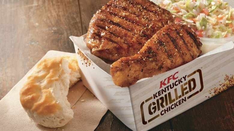 KFC's Kentucky Grilled Chicken in a box with coleslaw next to a biscuit.