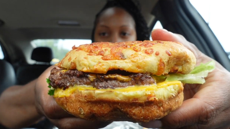 Woman holding Wendy's Loaded Nacho Cheeseburger
