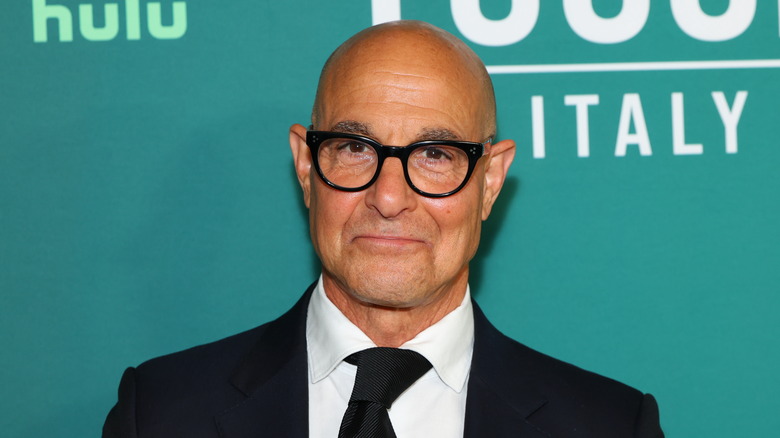 Stanley Tucci against a blue background for "Tucci in Italy" premiere