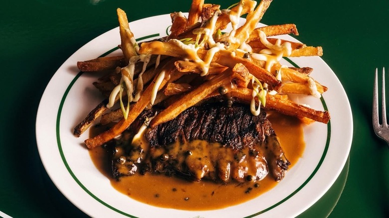 A steak frites from Torrisi on a green background