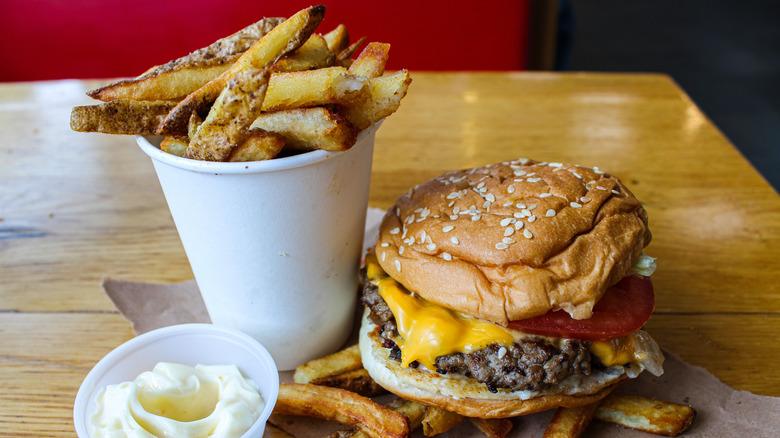 A cheeseburger with fries and a side of mayo from Five Guys