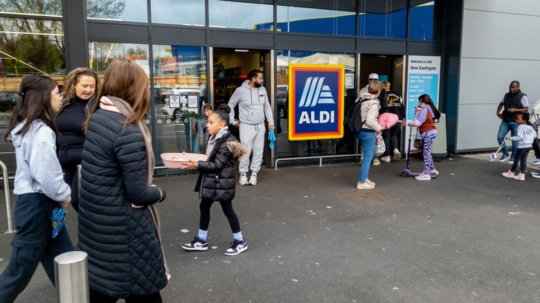 Various shoppers outside of Aldi storefront.