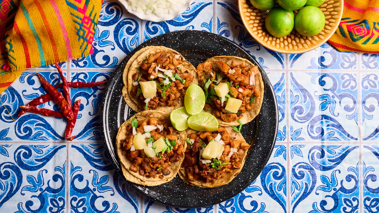 Plate of tacos al pastor with limes