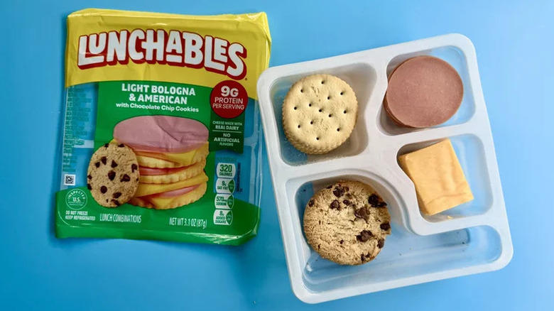 Light Bologna & American Lunchable next to its plastic wrapper on a blue background