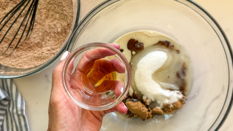 hand adding vanilla to pot