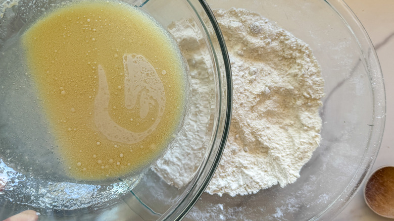 pouring wet ingredients into dry