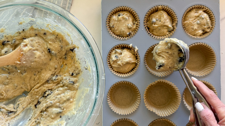 hand adding batter to muffin cup