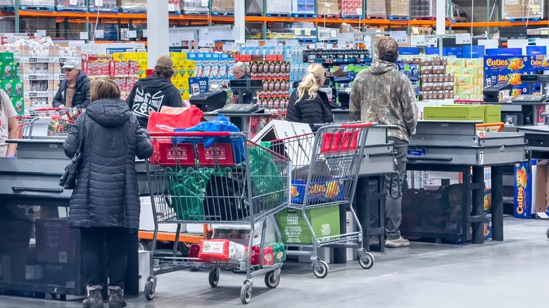 Lines of shoppers checking out their carts in a Canadian Costco store