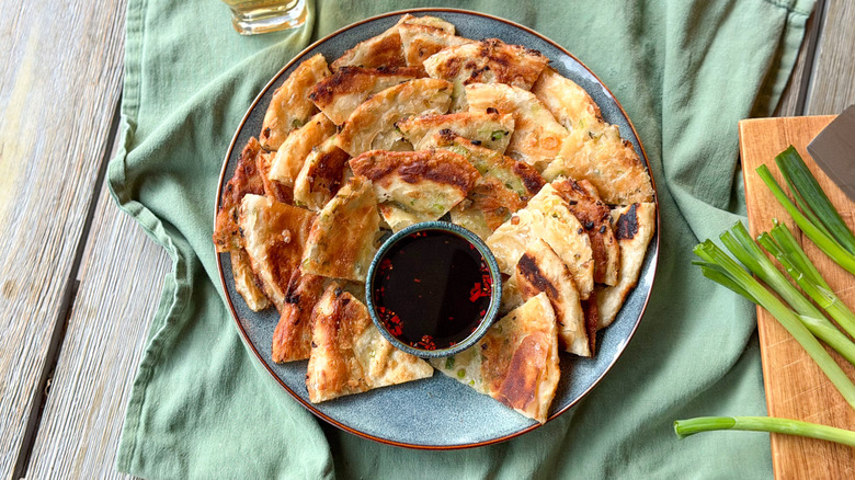 Scallion pancakes on serving platter with dipping sauce