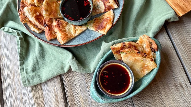 Scallion pancakes and dipping sauce on serving platter and plate