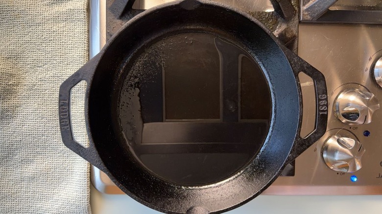 Cast iron skillet with peanut oil on stovetop