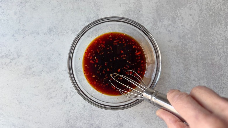 Whisking dipping sauce for scallion pancakes in small glass bowl