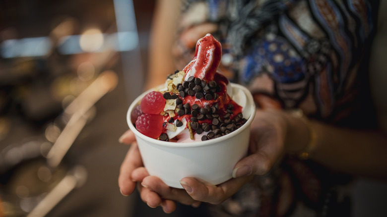 Person holding frozen yogurt cup