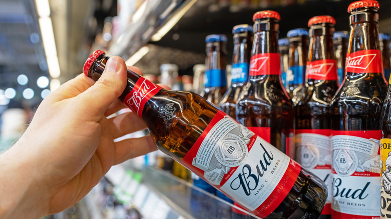 Person reaching for a glass of Bud.
