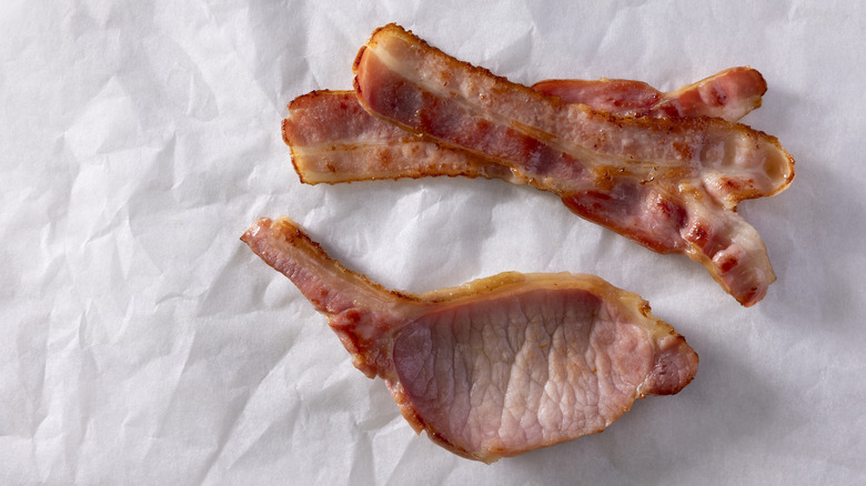 thin cut and thick cut bacon on a white parchment paper background