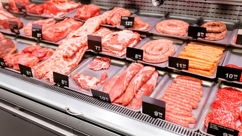 A meat department case with prices