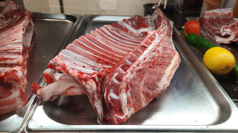 A large rack of ribs on a metal platter
