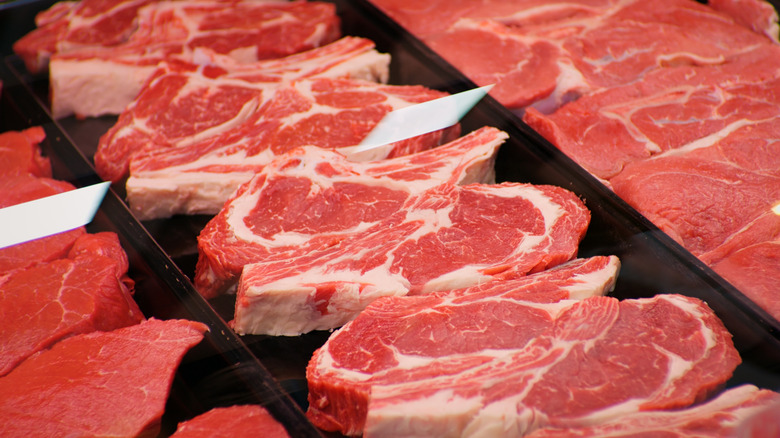 Thick cuts of raw beef in neat rows.