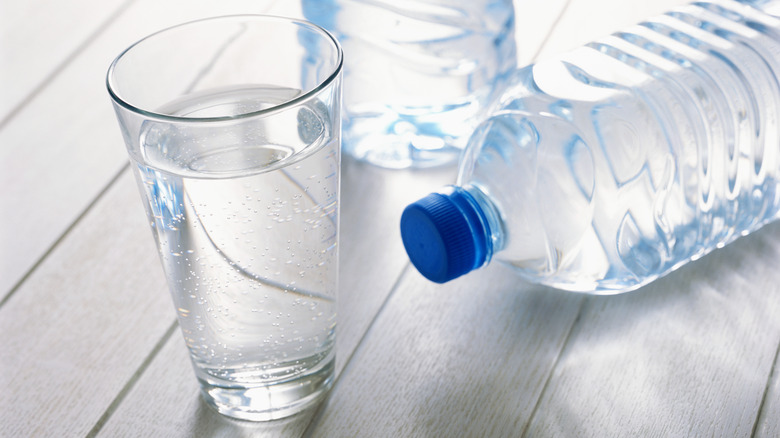 Two plastic bottles and a glass