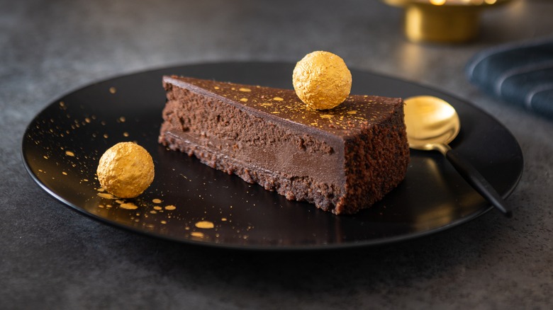 chocolate cake on plate with golden balls as garnish
