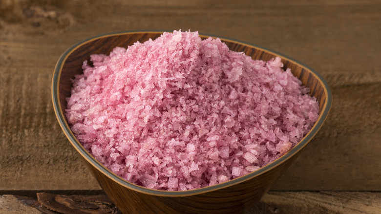 Reddish red wine salt in a bowl on a wooden table