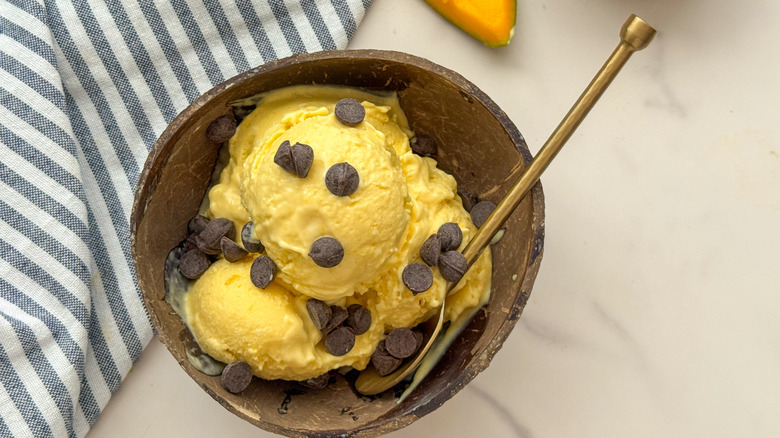 Mango ice cream in bowl topped with chocolate chips