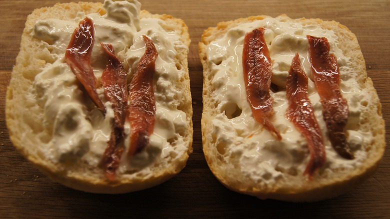 Two pieces of ciabatta bread with slices of anchovy layered on top