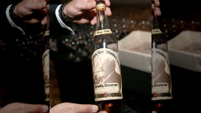 Holding a bottle of Pappy Van Winkle bourbon