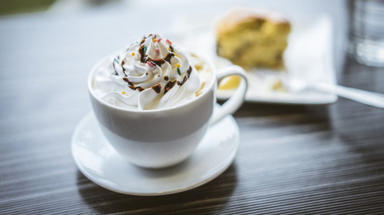 A cup of coffee topped with whipped cream.