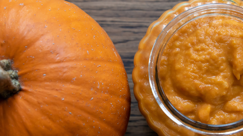 whole pumpkin next to pumpkin puree