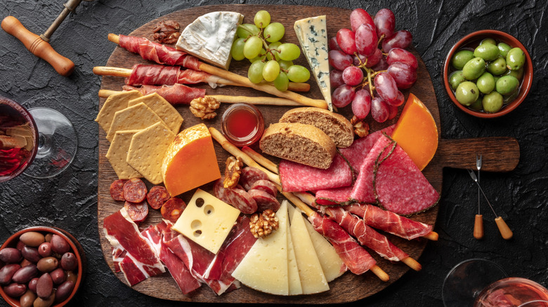 A huge cheese and charcuterie board is photographed from above